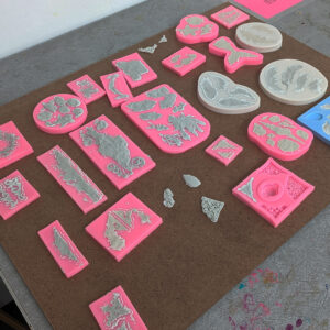 Pink molds with paper clay.