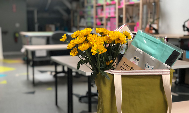 Tote kit and yellow flowers in tote bag, textiles studio.